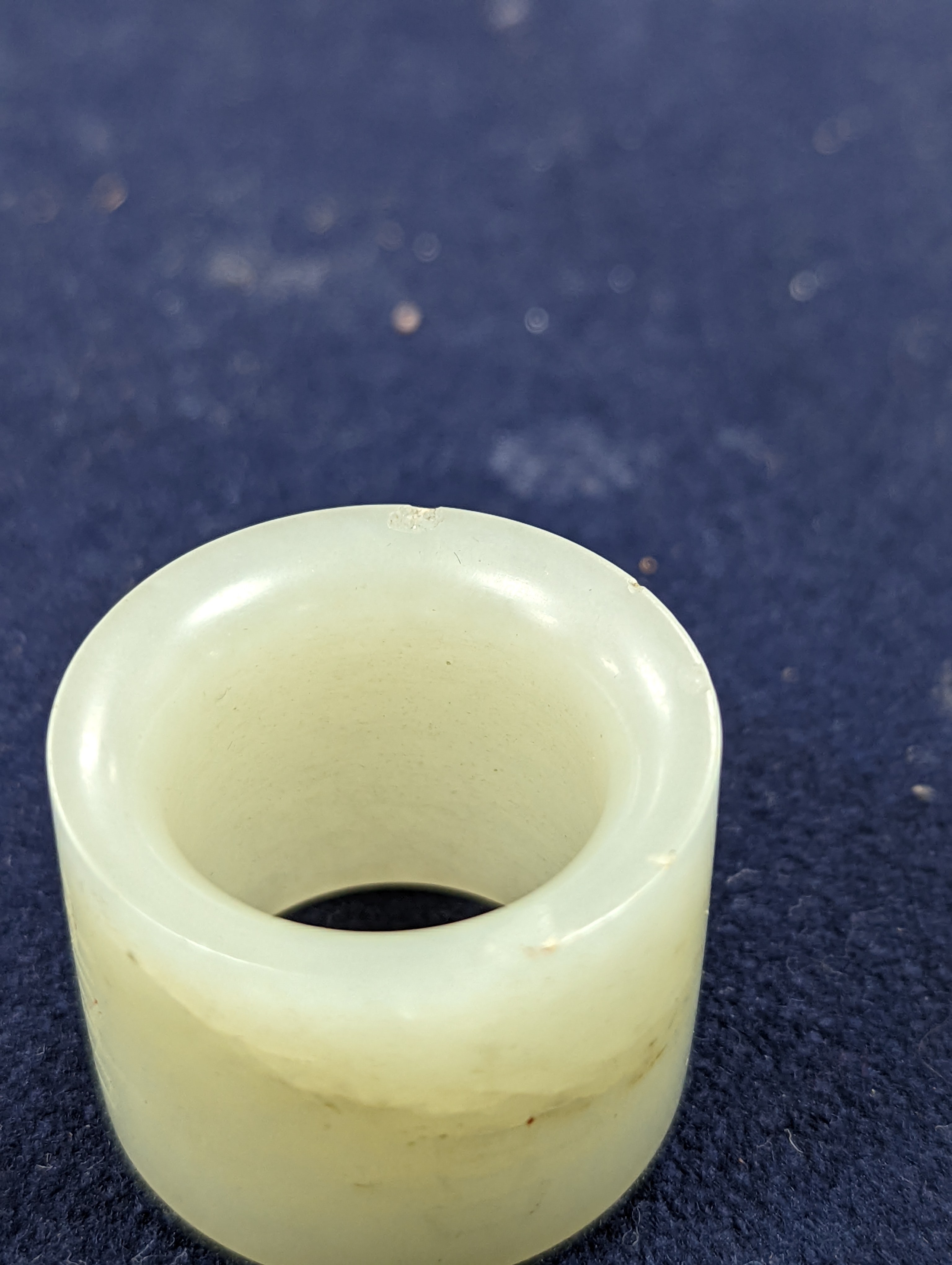 A 19th century Chinese pale celadon jade archer’s thumb ring, inscribed, 3 cm diameter
